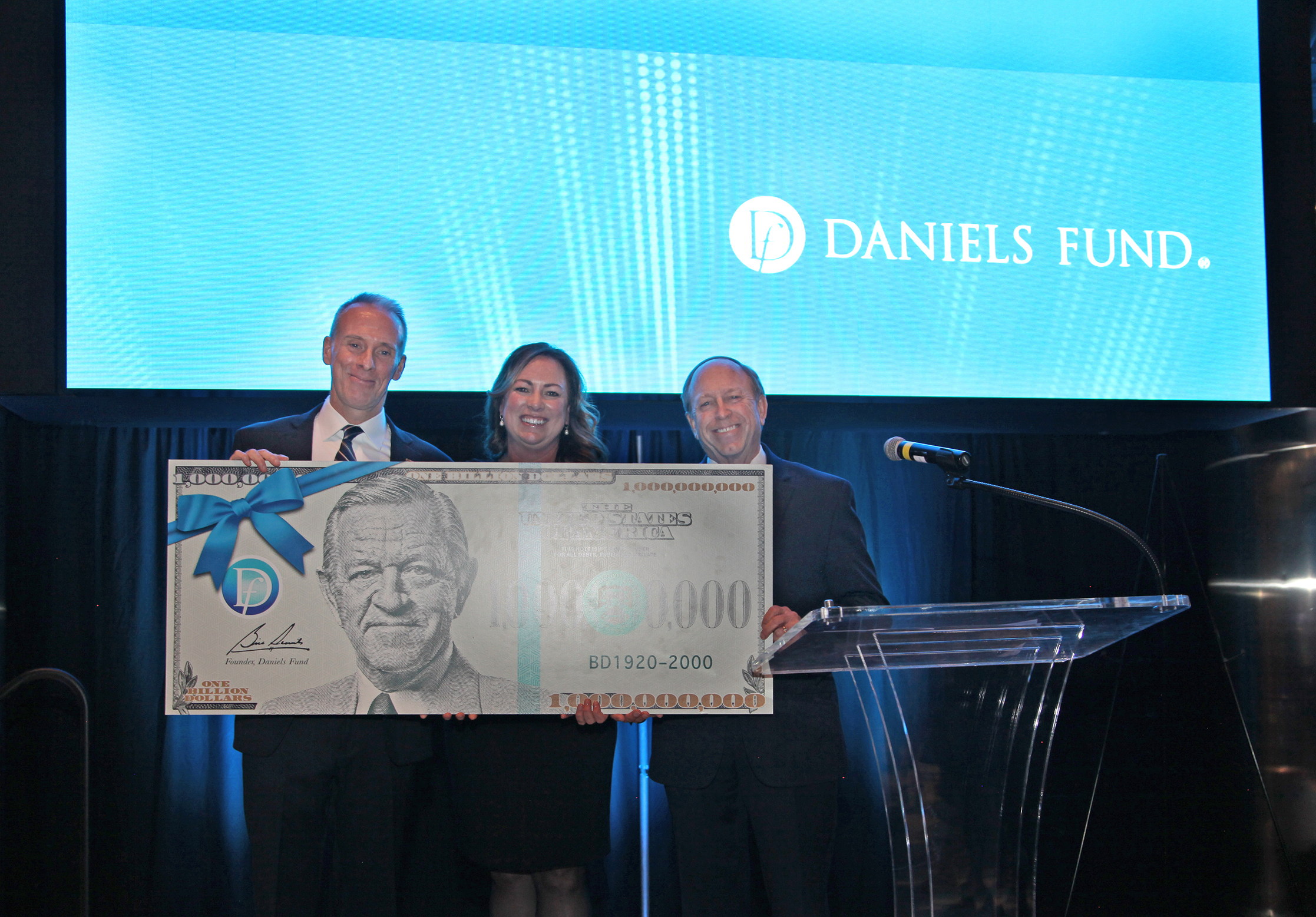 Michael O'Hagan, Hanna Skandera, and John Suthers with large check